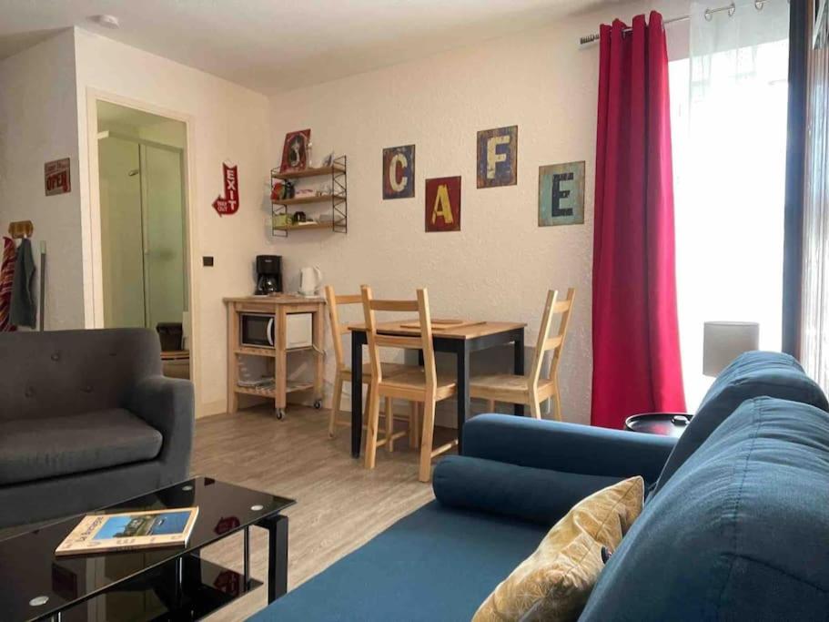 een woonkamer met een blauwe bank en een tafel bij Studio tout équipé centre ville Dol de Bretagne in Dol-de-Bretagne