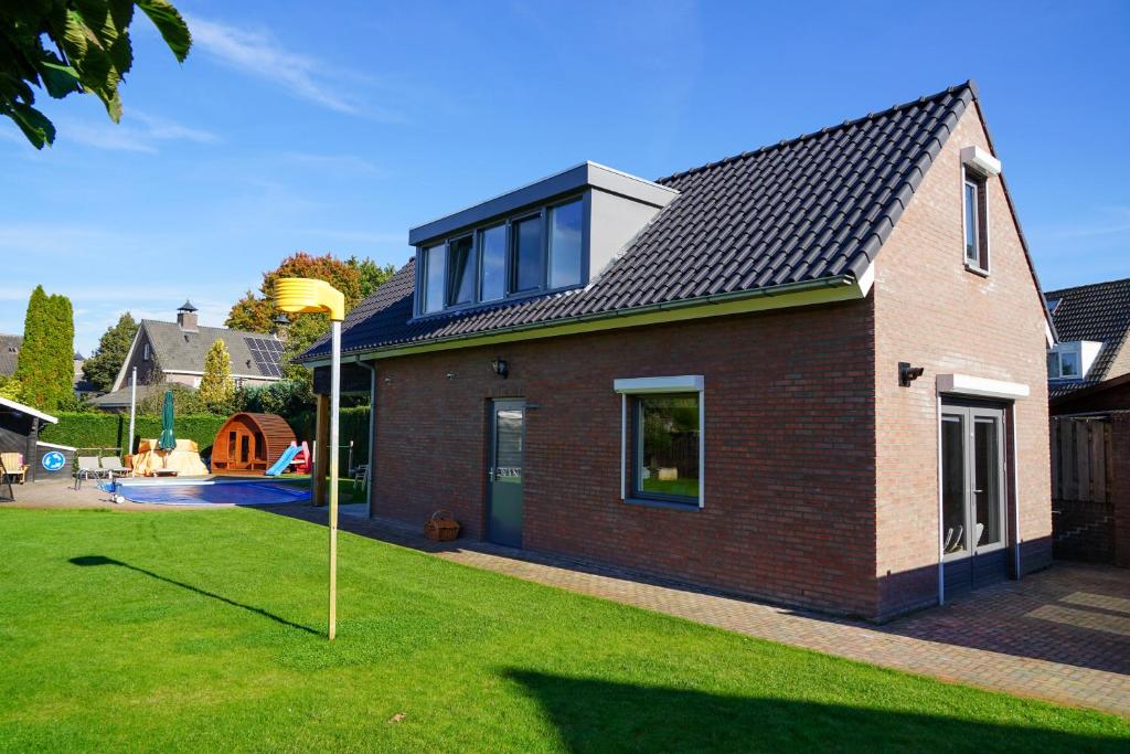 a red brick house with a gambrel roof at Prachtig royaal gastenverblijf in Schijndel