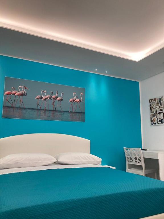 sypialnia z łóżkiem z obrazem flamingów w obiekcie LA DARSENA rooms w mieście Margherita di Savoia