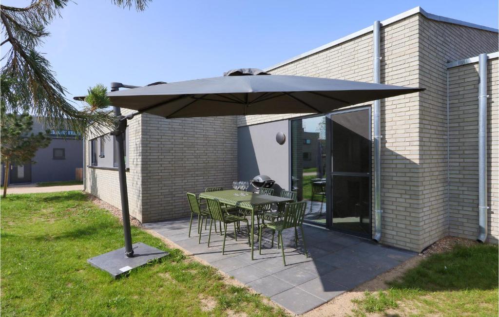 a patio with a table and chairs under an umbrella at Gorgeous Home In Lembruchdümmer See in Lembruch