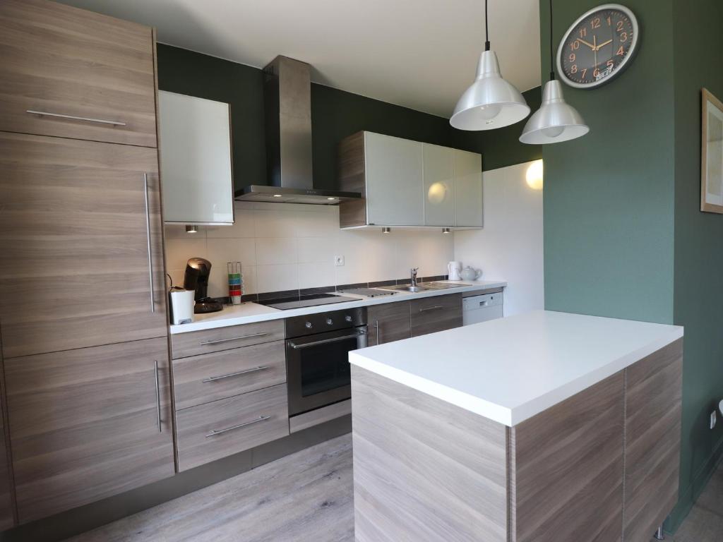 a kitchen with wooden cabinets and a clock on the wall at Appartement Annecy, 3 pièces, 6 personnes - FR-1-432-4 in Annecy