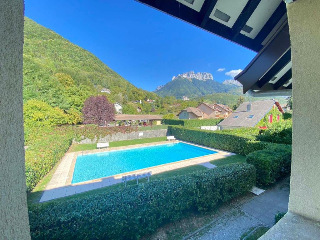 a swimming pool in a yard with a hill at Appartement 3* avec balcon, piscine et lac à proximité, activités diverses - FR-1-432-4 in Annecy