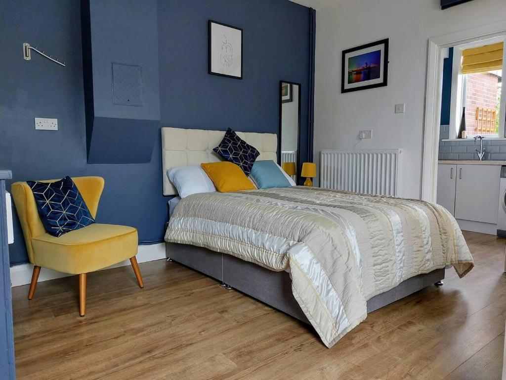 a bedroom with a large bed and a yellow chair at Inviting 1-Bed Apartment in Herne Bay in Herne Bay