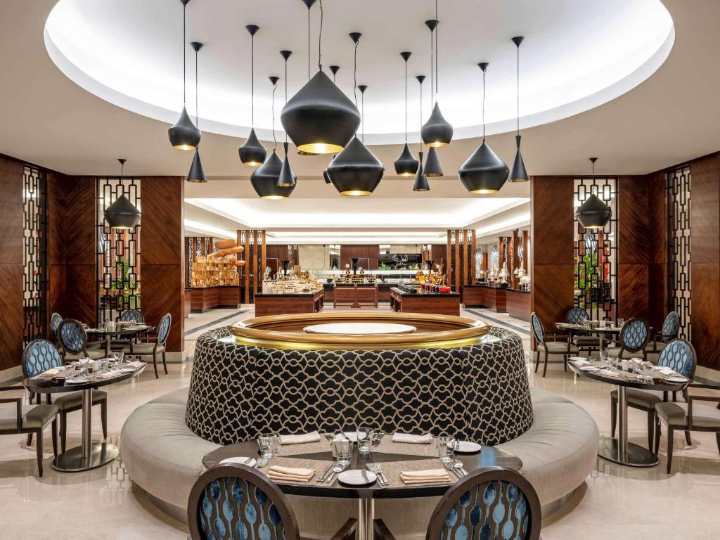a restaurant with a large round table and chairs at Swissotel Al Maqam Makkah in Mecca