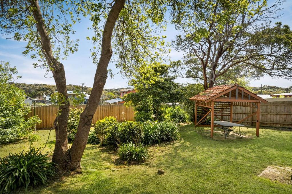 a backyard with a wooden gazebo and a tree at Little Island Escape in Sunset Strip