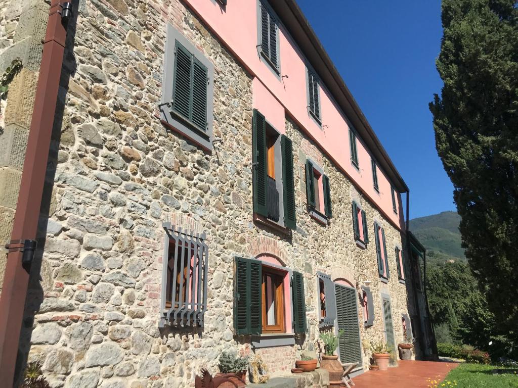 an old stone building with green shuttered windows at Bed&Breakfast La Madonnina in Marlia