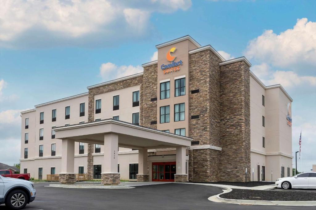 ein Hotelgebäude mit einem Auto auf einem Parkplatz in der Unterkunft Comfort Suites in Paducah