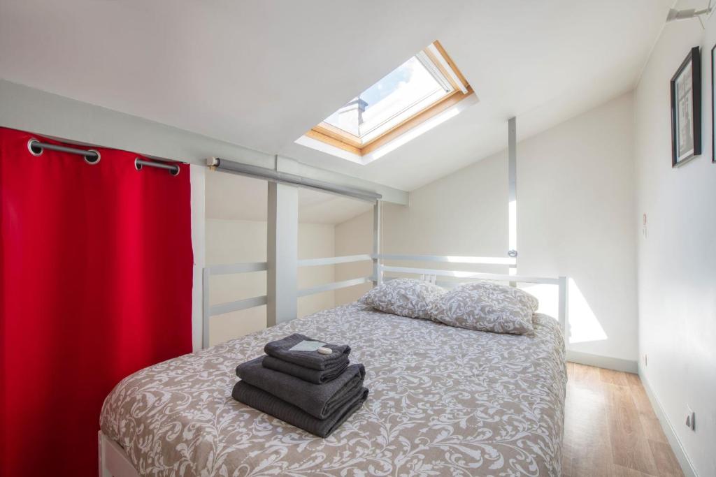 sypialnia z łóżkiem z czerwoną zasłoną w obiekcie BENFLEET 4 Cosy studio avec grande terrasse de 25 m2 w mieście Romainville