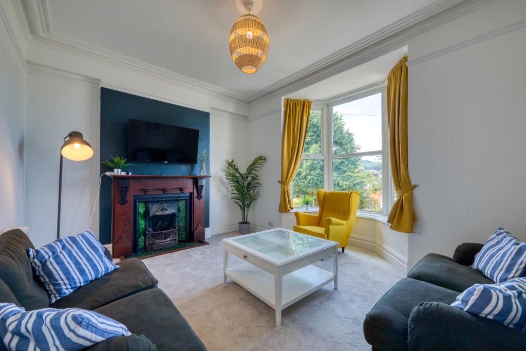 a living room with two couches and a fireplace at Brent House - 4 bedroom home close to shops, harbour & beaches in Ilfracombe