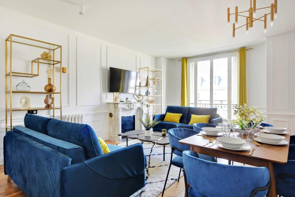 uma sala de estar com cadeiras azuis e uma mesa em Amazing Appart 3BR-6P - Bastille -Gare de Lyon 3 em Paris
