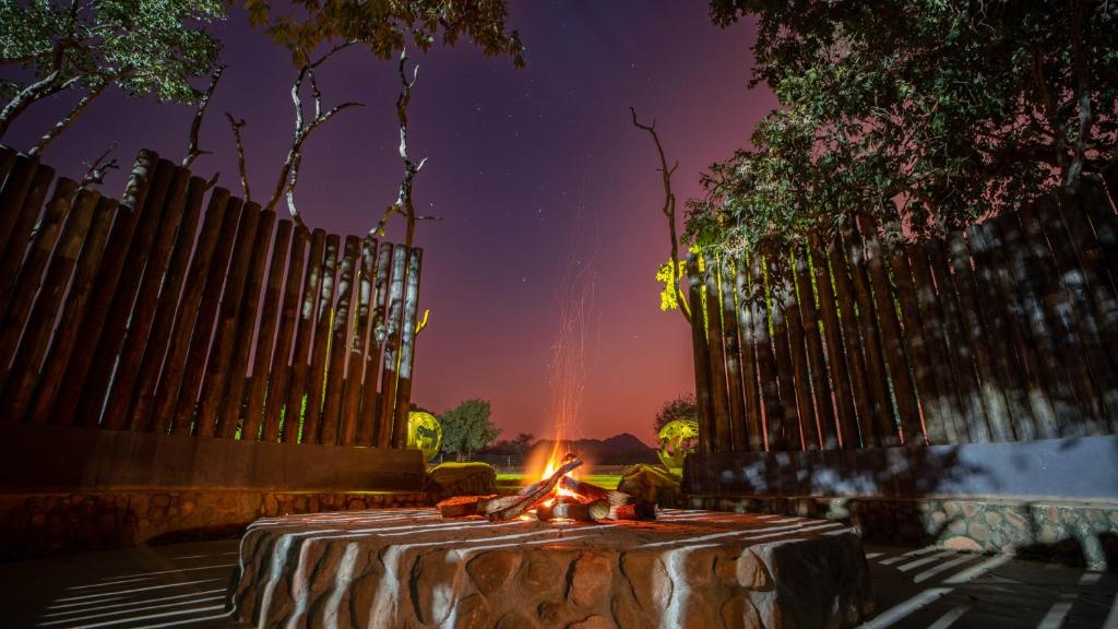 a table with a fire in front of a fence at Kilima Private Game Reserve & Spa in Gravelotte