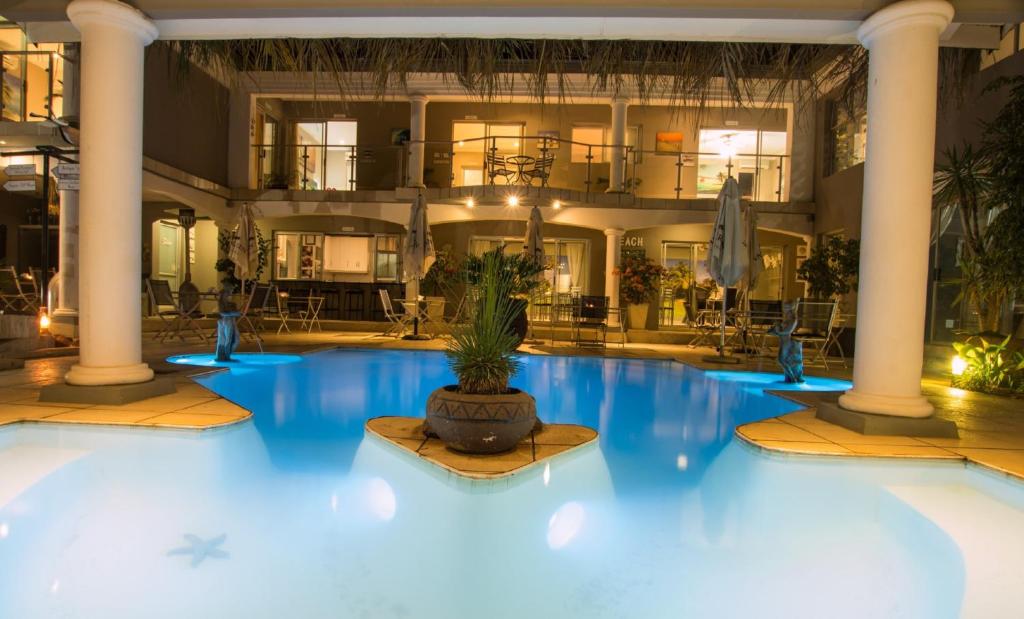 哈特比斯普特的住宿－Club Cocomo，一座大游泳池,在一座建筑前有盆栽植物