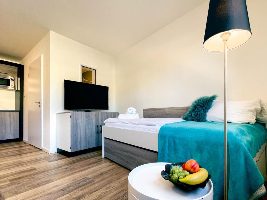una camera da letto con un letto e una ciotola di frutta su un tavolo di Stilvolles Apartment mit Parkplatz, barrierefrei a Reinheim