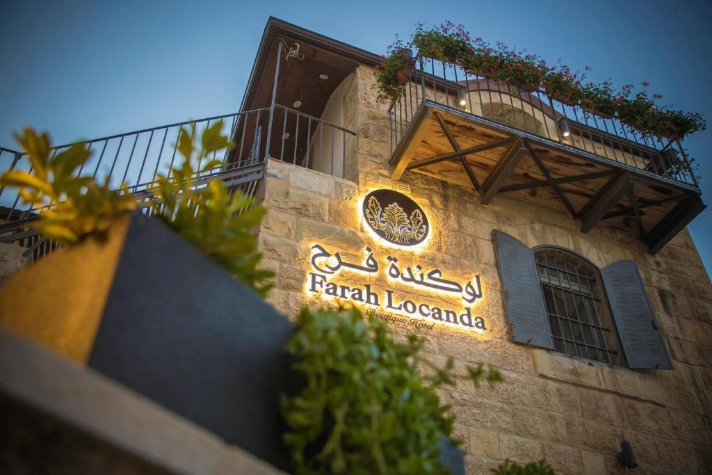 una señal en el lateral de un edificio en Farah Locanda en Ramallah