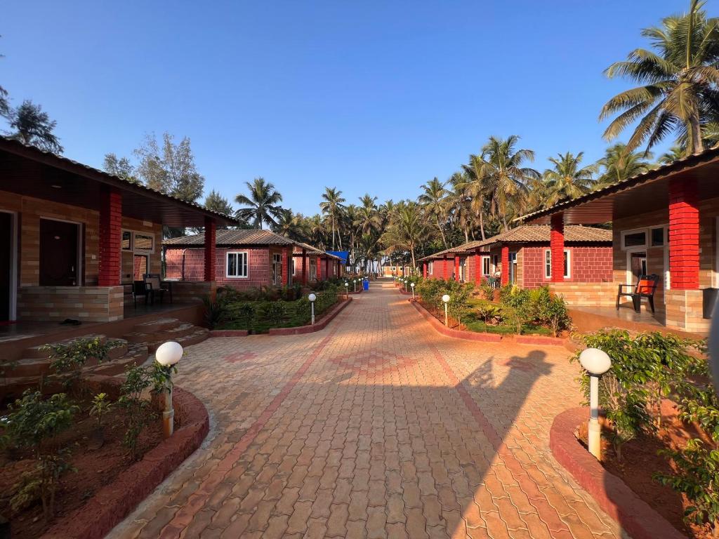 a cobblestone street with buildings and palm trees at Atlantis Beach Resorts in Kumta
