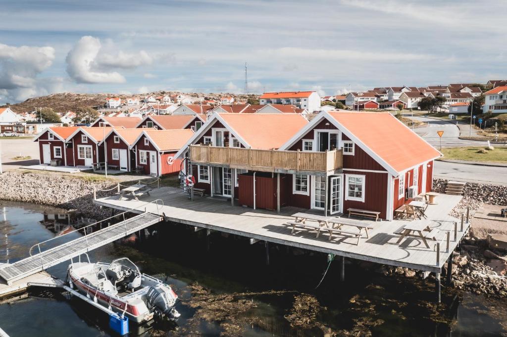 un grupo de casas en un muelle con un barco en Havets Magasin, en Väjern