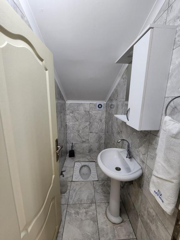 a small bathroom with a sink and a toilet at Esa Suite Hotel in Trabzon