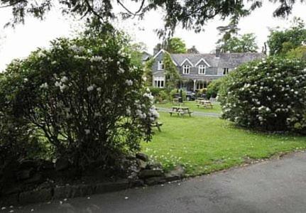 a large house with a picnic table in the yard at Ty Mawr Hotel in Llanbedr