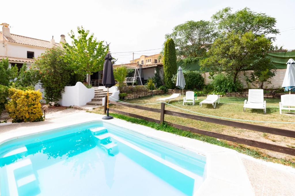 - une piscine dans une cour avec des chaises et des parasols dans l'établissement Cortijo mirasol, à Santa Cruz de Comercio