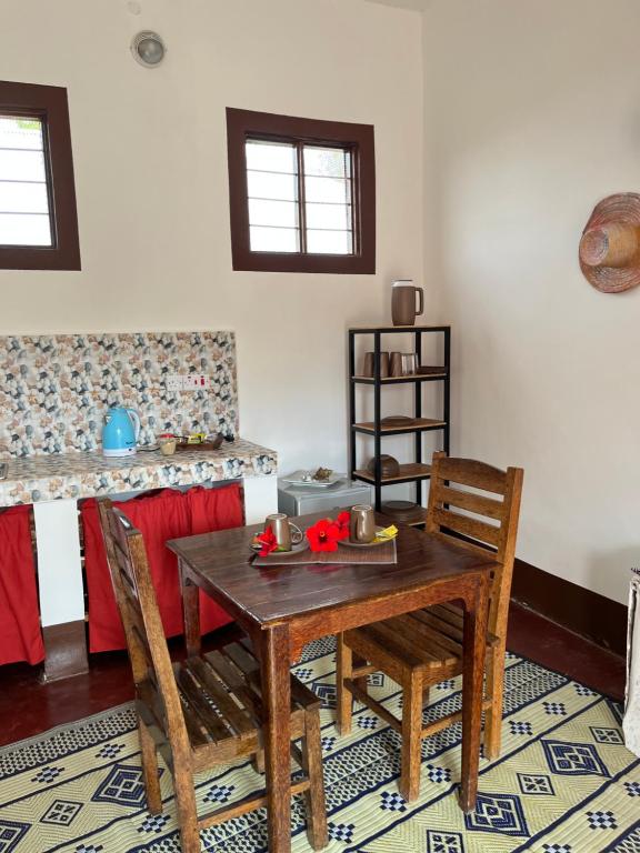 a dining room with a wooden table and chairs at Habibi B&B in Uroa