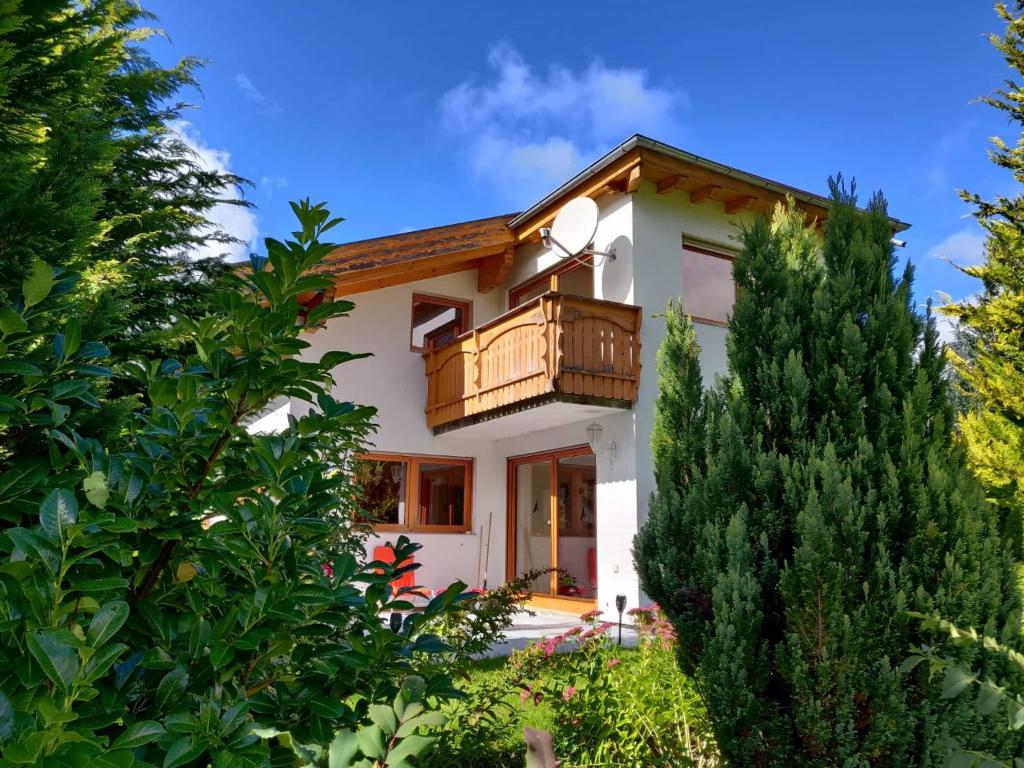 une maison avec un balcon et des arbres dans l'établissement Appartement Alpenliebe, à Bichlbach