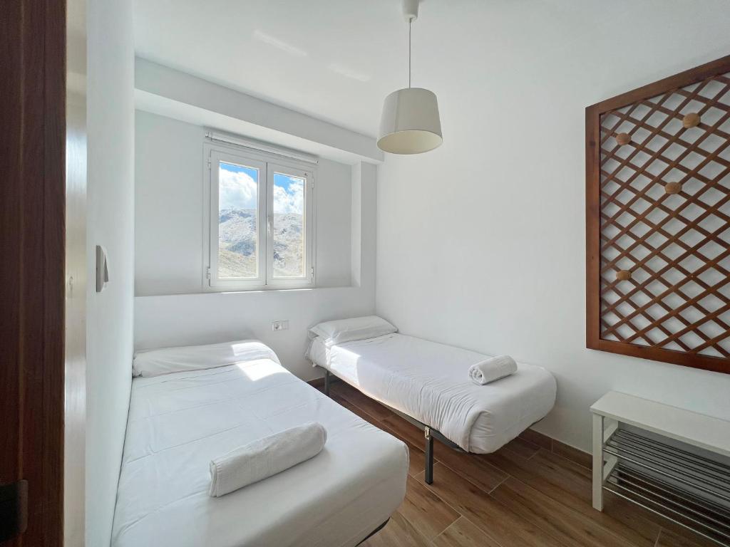 Łóżko lub łóżka w pokoju w obiekcie Apartamentos Sierra Nevada 3000