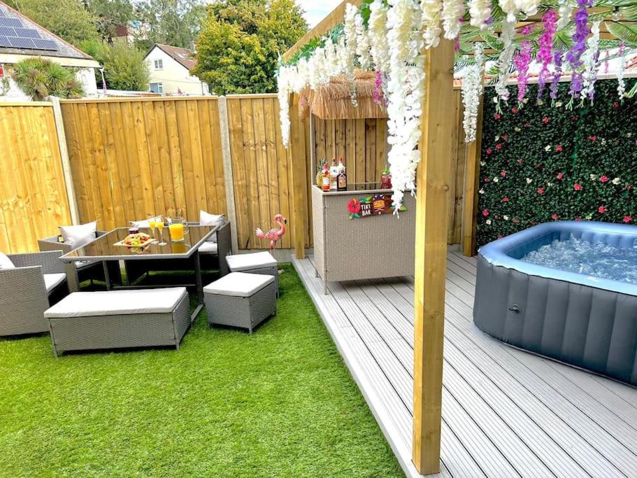 een achtertuin met een hot tub en een tafel en stoelen bij Stylish 3 bedroom seaside escape - newly renovated in Paignton
