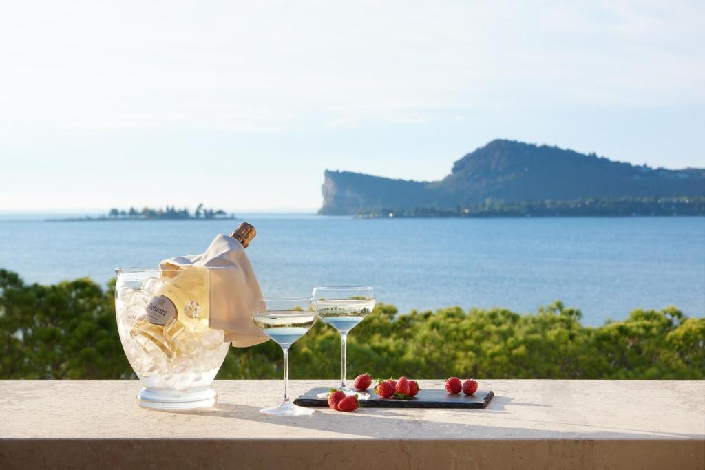 サン・フェリーチェ・デル・ベナーコにあるホテル リストランテ ソーニョのワイン2杯とフルーツプレート付きテーブル