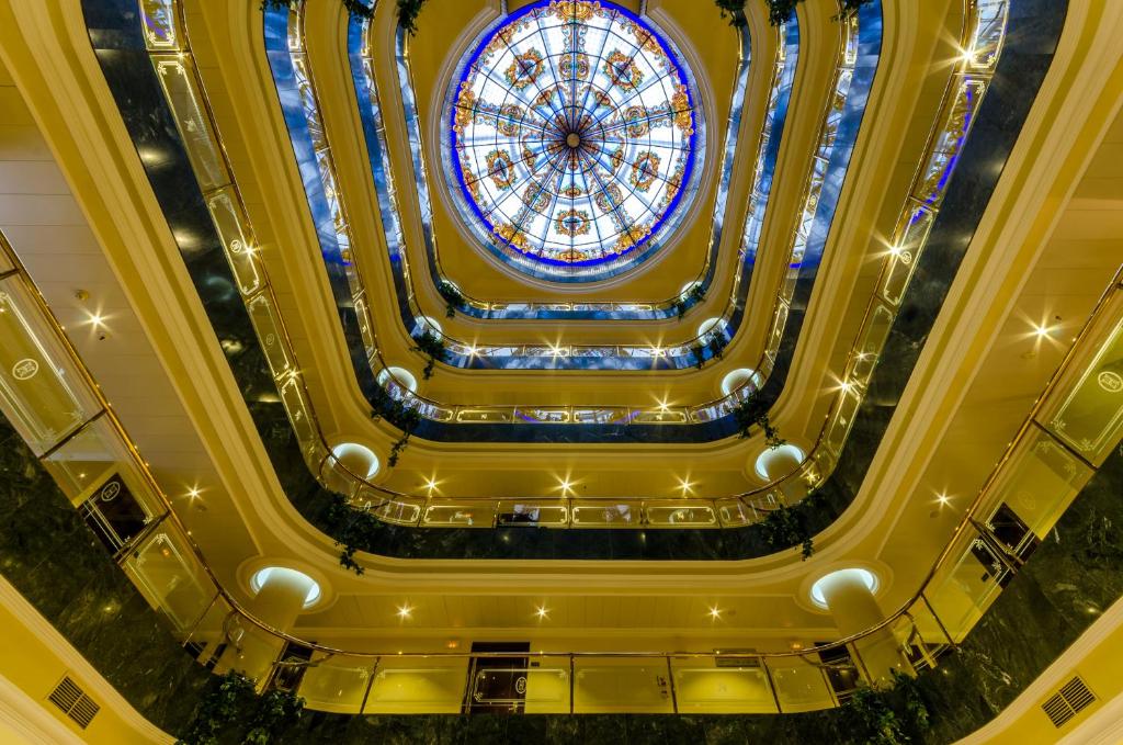 a ceiling view of a building with a stained glass window at Infanta Cristina in Jaén