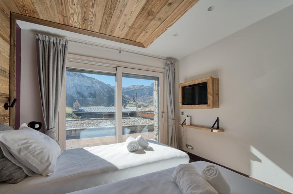 a bedroom with two beds and a large window at Chalet Ancolie in Tignes