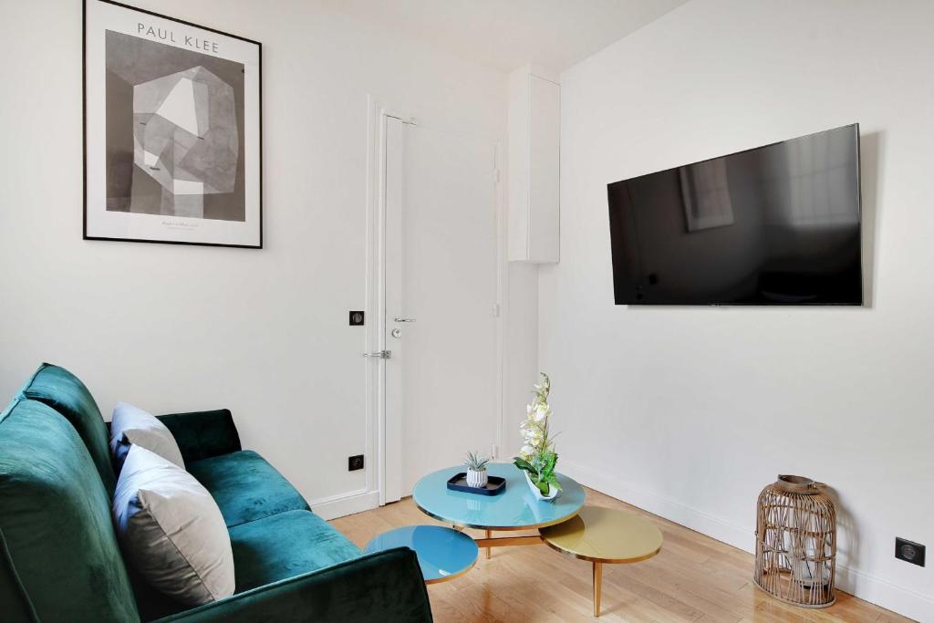 ein Wohnzimmer mit einem grünen Sofa und einem Tisch in der Unterkunft Amazing Appart 2BR/6P - Bastille/ Gare de Lyon 4 in Paris