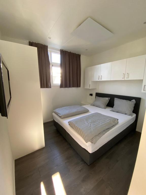 Un pat sau paturi într-o cameră la LUXUS Cube Ferienhaus Chalet am See mit Schwimmbad in Lathum NL