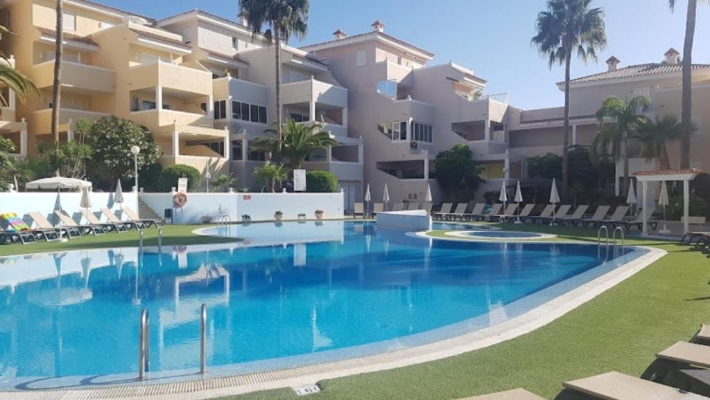 アロナにあるChayofa Country Clubの大きなアパートメントの建物の前にスイミングプールがあります。