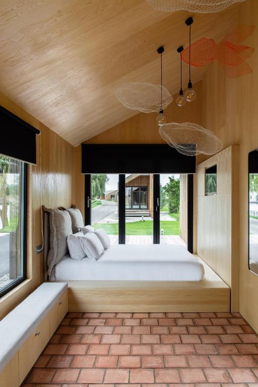 a bedroom with a large bed and a large window at ARCA Resort 