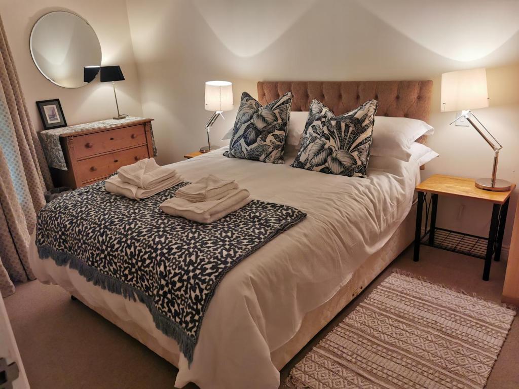 um quarto com uma cama grande, uma mesa e um espelho. em Newport Harbourside 2 bed Apartment with stunning views em Westport