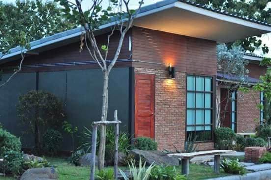 une petite maison avec un banc devant elle dans l'établissement Vwara Resort, à Buriram
