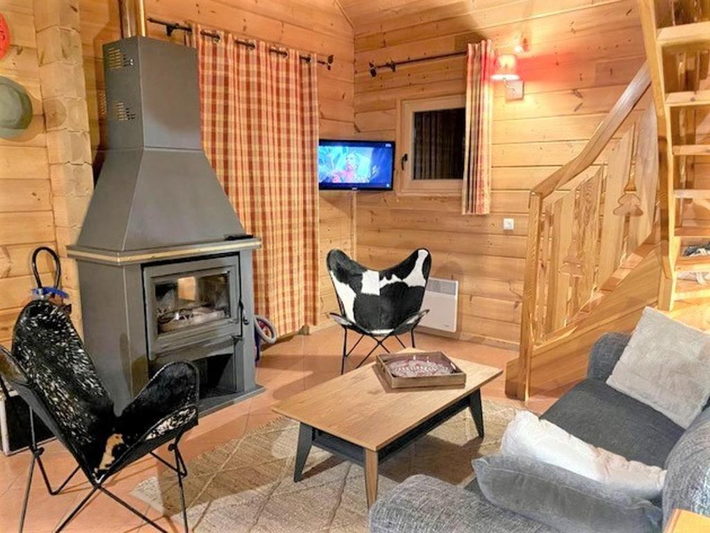 a living room with a fireplace in a log cabin at Chalet spacieux 5 pièces avec parking et terrasse à La Joue du Loup - FR-1-504-624 in Le Dévoluy