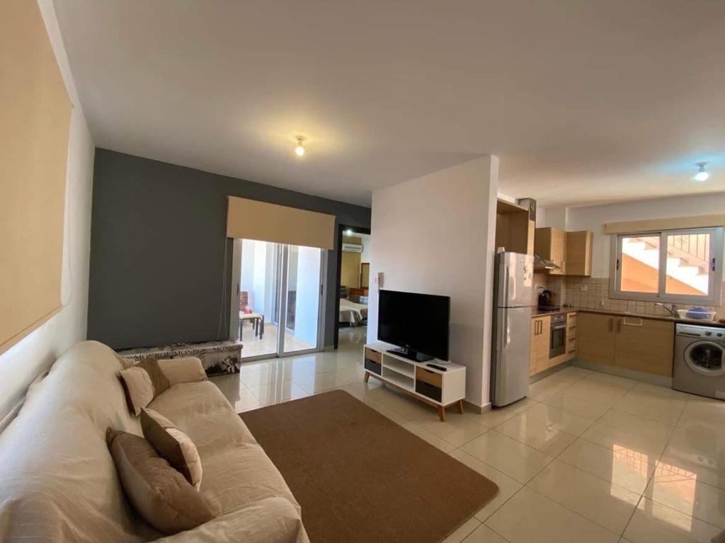 sala de estar amplia con sofá y cocina en Andris apartment, en Paralimni