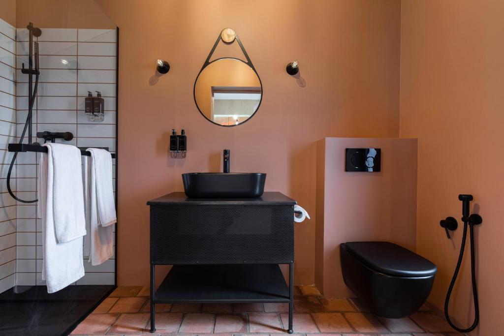 a bathroom with a black sink and a mirror at ARCA Resort 