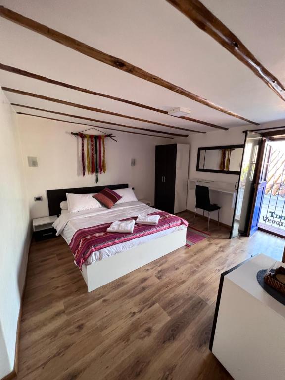 sypialnia z dużym łóżkiem w pokoju z drewnianą podłogą w obiekcie Casona les Pleiades w Cuzco