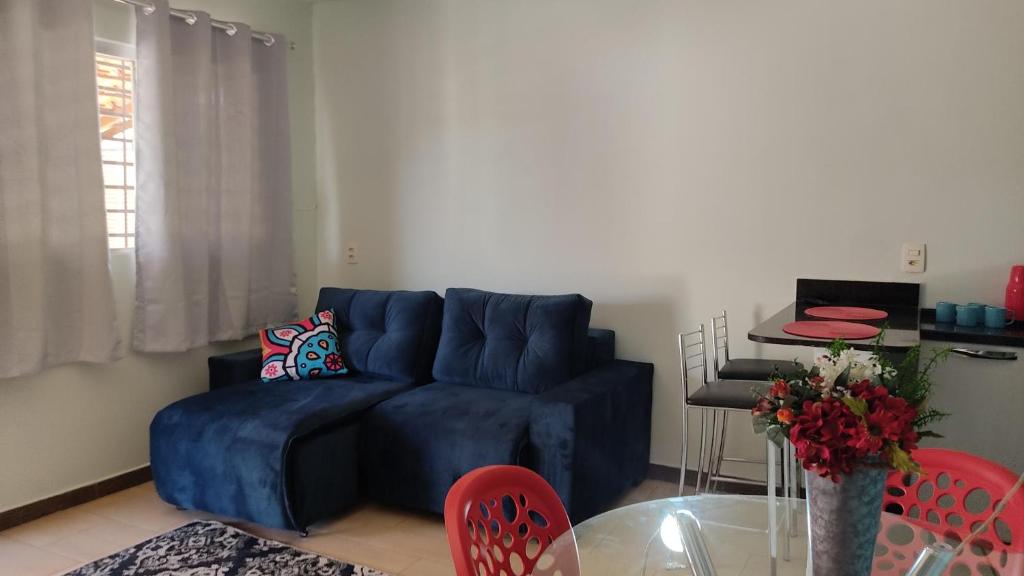 a living room with a blue couch and a glass table at Condomínio Capim Santo in Goiânia