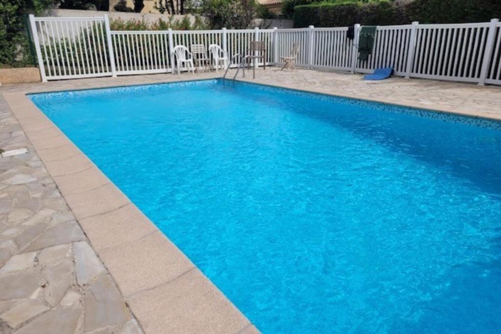 une grande piscine bleue dans une cour dans l'établissement Nice studio 30 m with terrace and pool, à Antibes