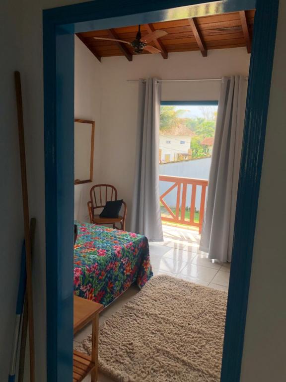 a bedroom with a bed and a view of a balcony at Casa aconchegante em bairro nobre da cidade Paraty in Paraty