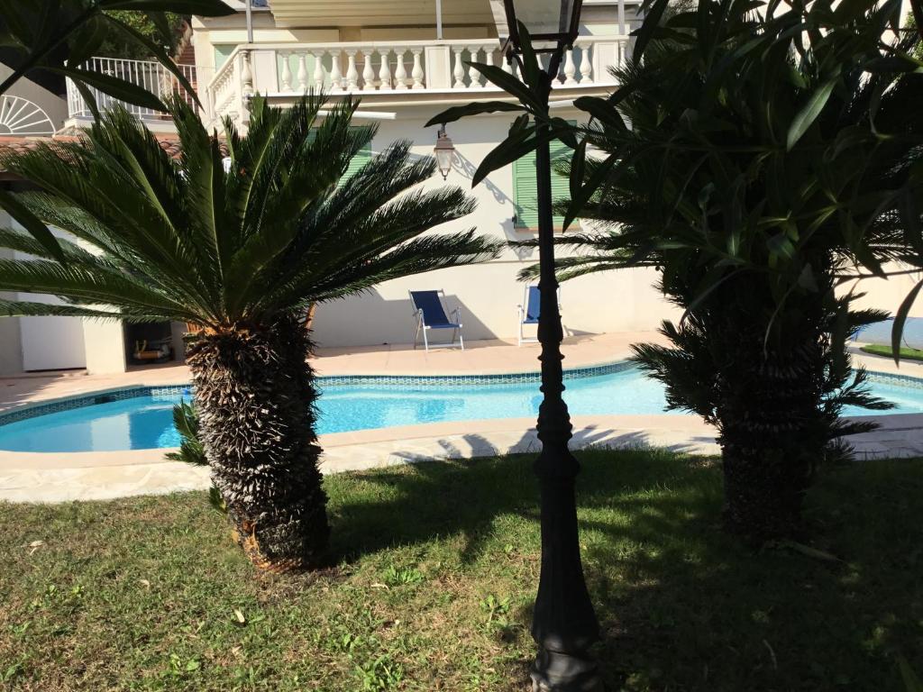 Villa Paradiso, logement avec piscine, Nice Nord في نيس: نخلتين امام مسبح