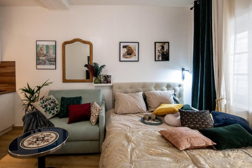 een woonkamer met een bed en een bank bij Le Gatsby Superbe cocon cosy proche place in Lyon
