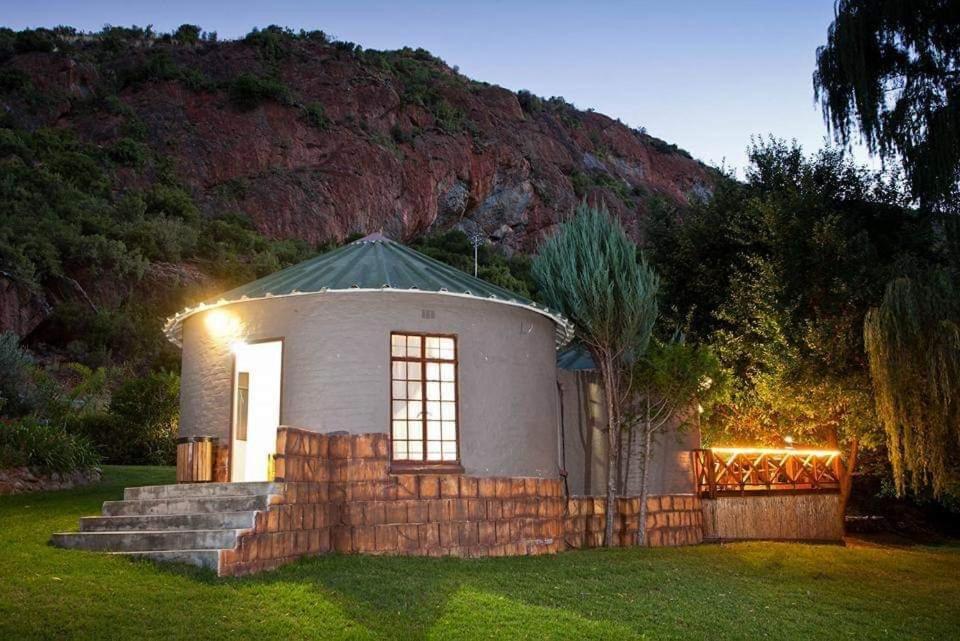 a small house with lights on the grass at Cango Retreat Quiet in Oudtshoorn