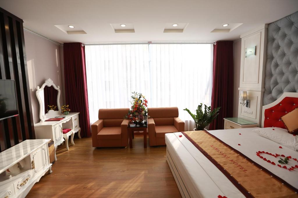 a bedroom with a bed and a living room at Kawasaki Hotel Cầu Giấy in Hanoi