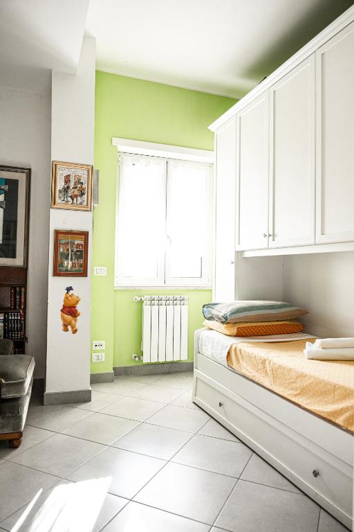 sypialnia z zielonymi ścianami, łóżkiem i oknem w obiekcie Il Forte Apartment w Rzymie