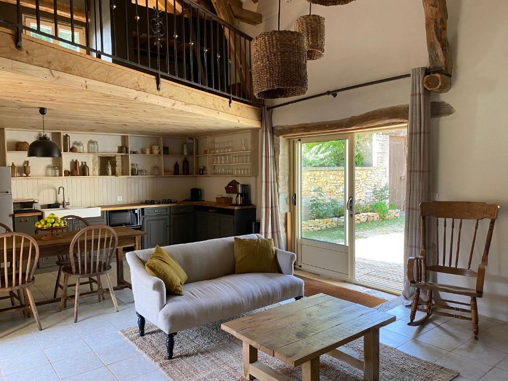 a living room with a couch and a table at Gîte Dordogne Périgord in Hautefort