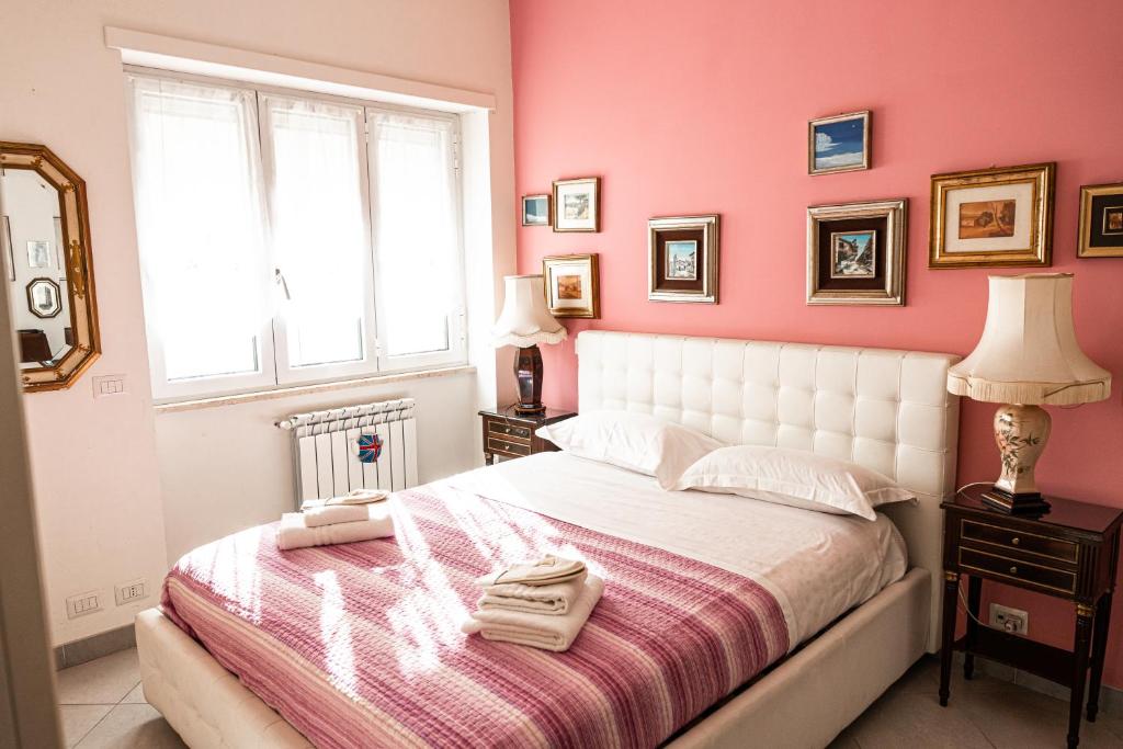 sypialnia z białym łóżkiem i różowymi ścianami w obiekcie Il Forte Apartment w Rzymie